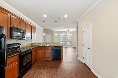 Kitchen featuring black appliances, dark hardwood