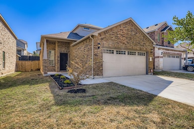 View of front facade with brick siding, driveway, an attached garage, and a shingled roof