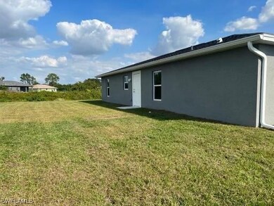 Back of property featuring a yard and stucco sidin