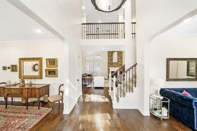 From the entry, you get a glimpse into the family room, hinting at the cozy and inviting atmosphere that awaits further inside.  The lovely wrought iron stair parts draw your attention to the staircase and the upstairs landing