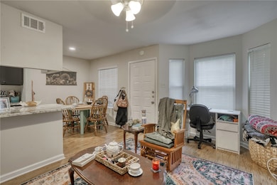 Living room featuring ceiling fan, light wood-styl