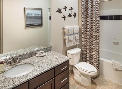 Full bathroom with tile floors, large vanity, toil