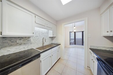 Updated cabinetry, under-cabinet lighting, and stainless-steel sink with pull-down faucet add style and function.