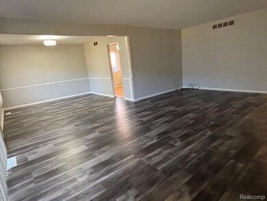Empty room featuring dark wood-style flooring and baseboards