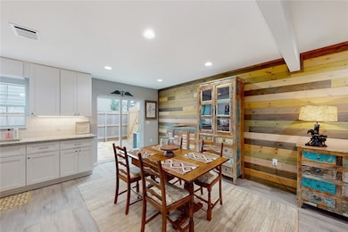 Dining space featuring wood accent wall, recessed