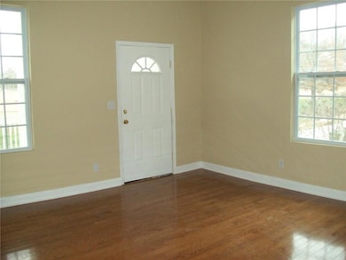 Foyer entrance with dark wood-style floors and baseboards