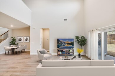 Living room featuring stairway, visible vents, a 