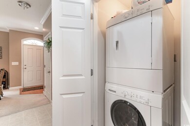 Laundry area with ornamental molding, stacked wash