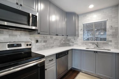Kitchen with gray cabinetry, stainless steel appl