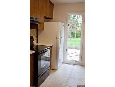Kitchen has porcelain tile flooring, Corian counte