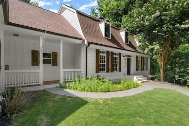 View of front of property with roof with shingles, a porch, a front yard, and board and batten siding