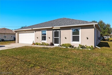 Single story home with a garage and a front lawn