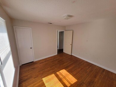 Unfurnished bedroom featuring hardwood / wood-style floors and a textured ceiling