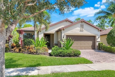 Ranch-style house featuring stucco siding, decorative driveway, a front yard, an attached garage, and stone siding