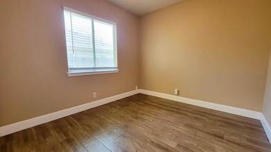 Spare room with dark wood-type flooring and baseb