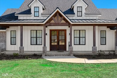 Front of home with French doors and cypress column