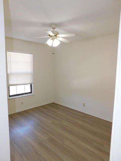 Unfurnished room with baseboards, wood finished f