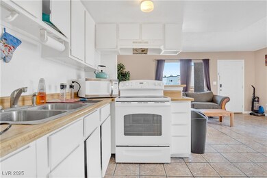 Kitchen featuring white appliances, light countert