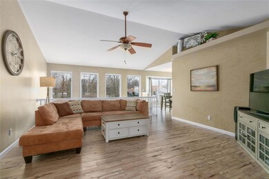 Vauted great room with laminate flooring, plant sh