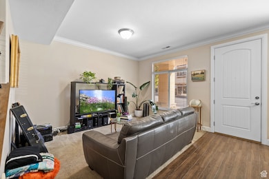 Living area featuring crown molding and wood finished floors