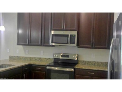 Stainless Steel Appliances with gleaming granite atop cocoa colored cabinets with crowns.