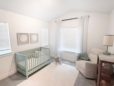 Bedroom with carpet flooring, lofted ceiling, and a crib