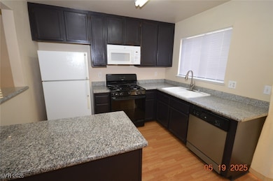 Kitchen featuring white appliances, a sink, and li