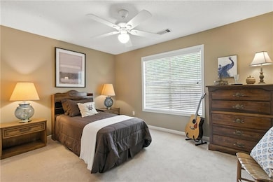 Bedroom with light colored carpet and ceiling fan