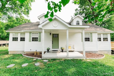 Bungalow-style home featuring a shingled roof, a front yard, and a porch