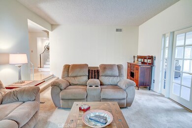 Living room with French doors to sun filled den/family room