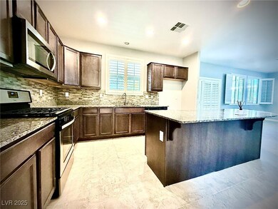 Kitchen with a kitchen bar, light stone counters,