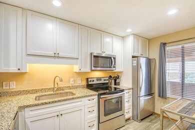 Kitchen with sink, white cabinetry, stainless stee