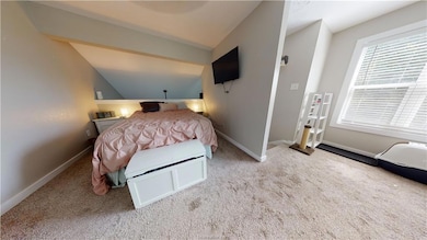 Carpeted bedroom featuring baseboards and vaulted