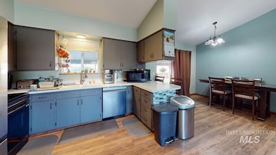 Kitchen featuring dishwasher, vaulted ceiling, electric stove, light wood-style flooring, and a peninsula