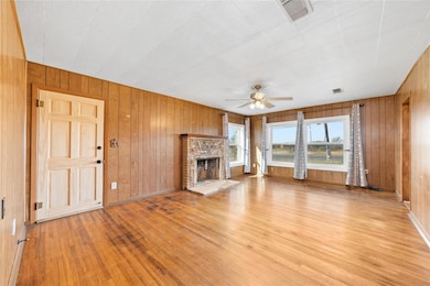 Living room with panelling, ceiling fan, a firepla