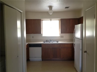 Kitchen featuring white appliances, a sink, light