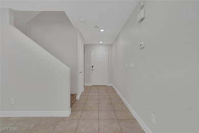 Hallway featuring light tile patterned flooring, b