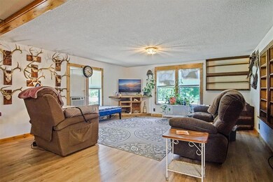 Living area featuring wood finished floors, a textured ceiling, and baseboards