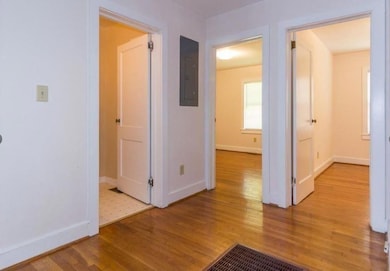 Hallway with electric panel and light hardwood / w