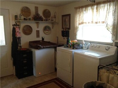 oversized laundry room with cabinets and closet for added storage with rear entrance to home.