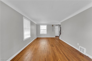 Unfurnished room with wood-type flooring and stairway