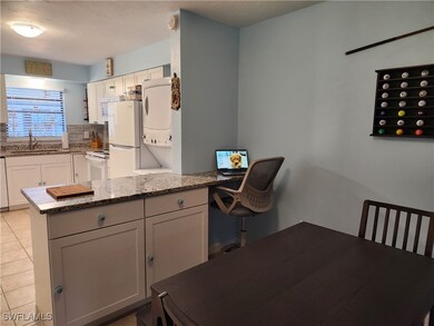 Kitchen featuring white cabinetry, sink, light sto