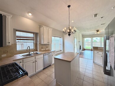 Cook with ease—gas stove, spacious island, tall cabinets, plus stainless steel fridge and dishwasher.