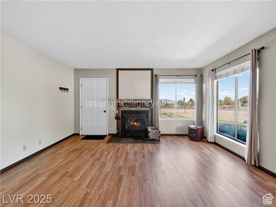 Living area with light wood-type flooring and a lit fireplace