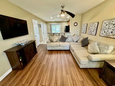 Living room with ceiling fan and hardwood / wood-s