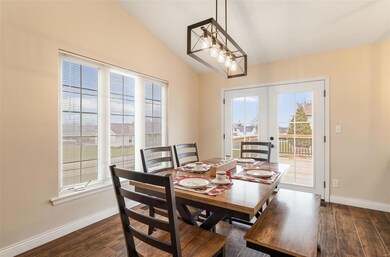 Dining space with a healthy amount of sunlight and medium oak porcelain /hardwood style flooring.               dw