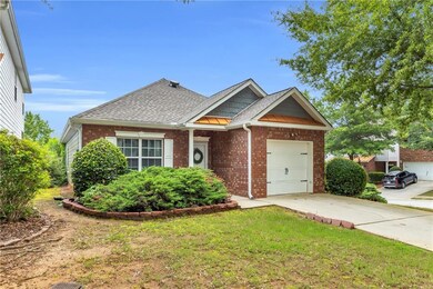 View of front of home with brick siding, an attached garage, a shingled roof, and driveway