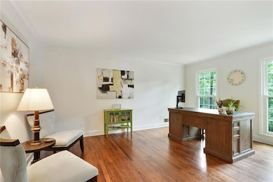 Office area with crown molding and wood finished floors