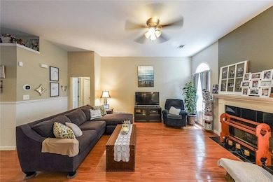 Living room featuring ceiling fan, wood finished f