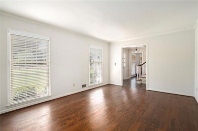 Unfurnished room with dark wood-style floors, crown molding, stairs, and baseboards